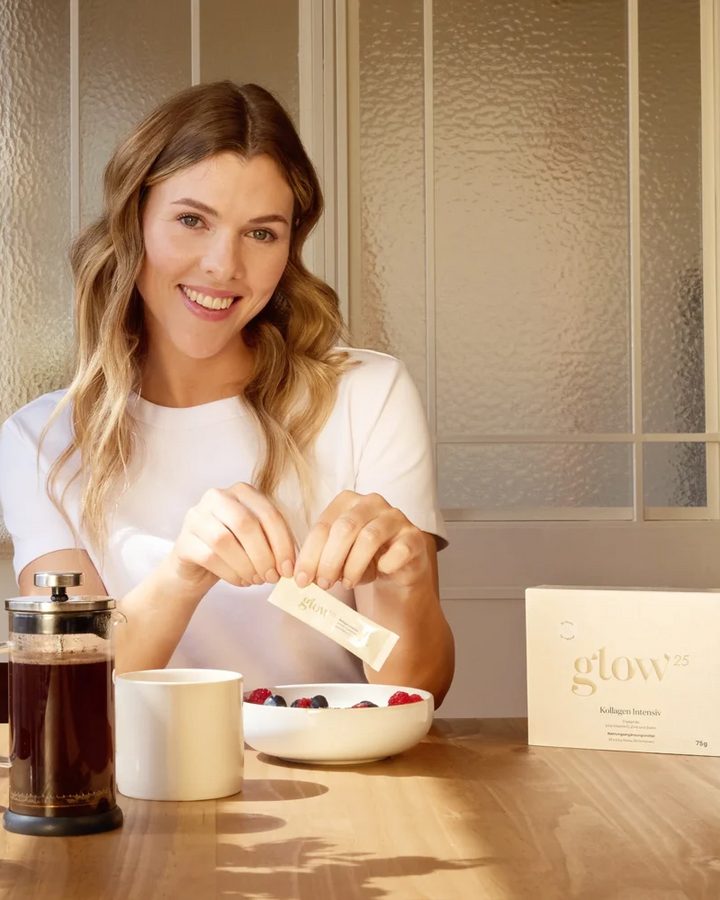 Vrouw aan het ontbijt roert Glow25 Collagen Intensive door haar drankje